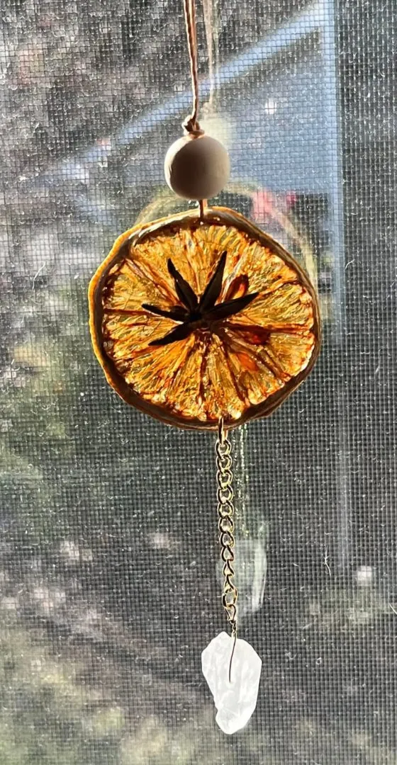 A dried-orange and crystal suncatcher in the window